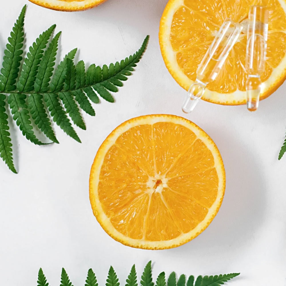 Orange Cut In Half With Green Leaves Around